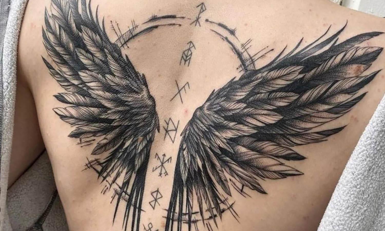 A tattoo of angel wings that shows the popular feathered form for angel  wings in tattoo art | Ratta Tattoo